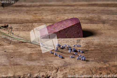 Image of Lavender cheese with bunch of fresh lavender flowers on rough wooden planks