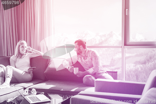 Image of couple relaxing at  home using tablet computer
