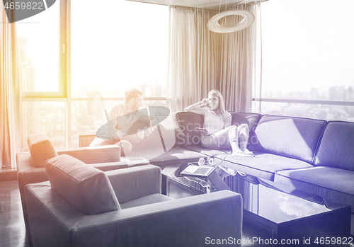 Image of couple relaxing at  home using tablet computer