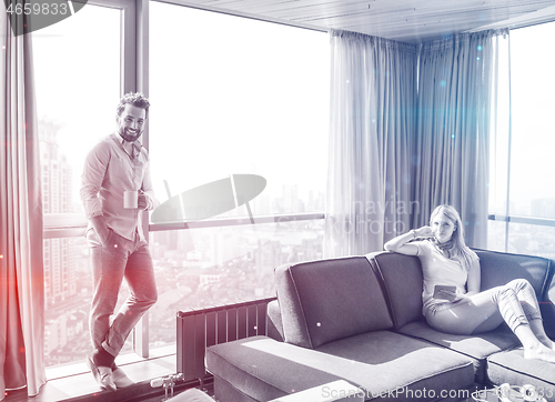 Image of couple relaxing at  home using tablet computer