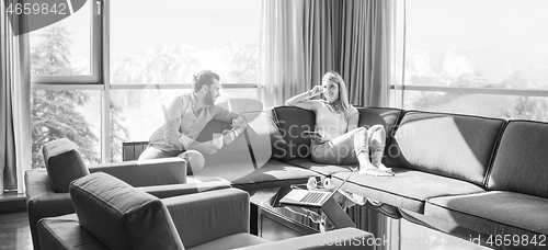 Image of couple relaxing at  home using tablet computer