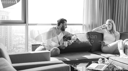 Image of couple relaxing at  home using tablet computer