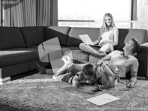 Image of young couple spending time with kids at home