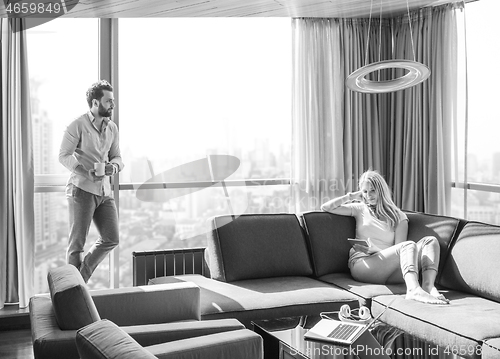 Image of couple relaxing at  home using tablet computer