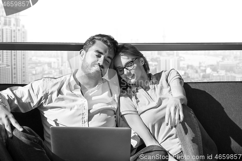 Image of couple relaxing at  home using laptop computers