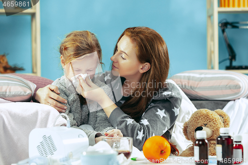 Image of Sick woman with daughter at home. The ill family.