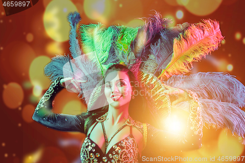 Image of Beautiful young woman in carnival peacock costume