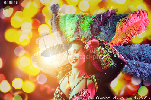 Image of Beautiful young woman in carnival peacock costume