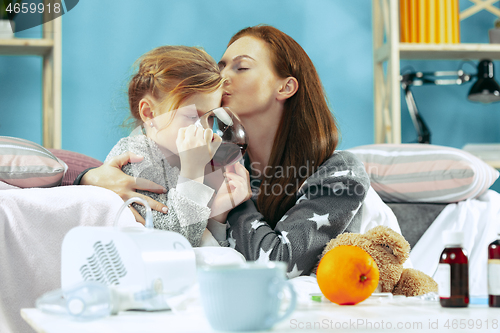 Image of Sick woman with daughter at home. The ill family.