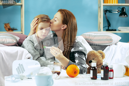 Image of Sick woman with daughter at home. The ill family.