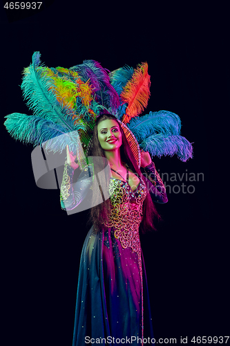 Image of Beautiful young woman in carnival peacock costume