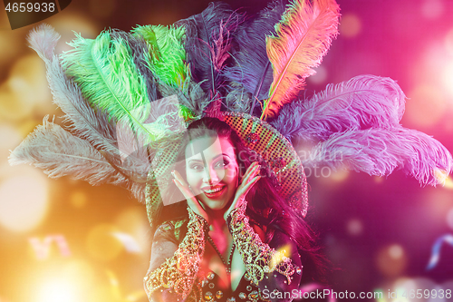 Image of Beautiful young woman in carnival peacock costume