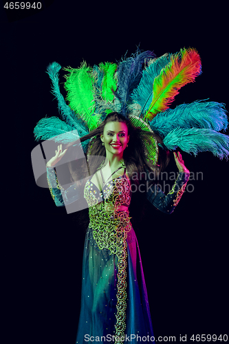 Image of Beautiful young woman in carnival peacock costume