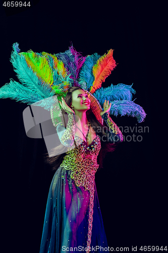 Image of Beautiful young woman in carnival peacock costume