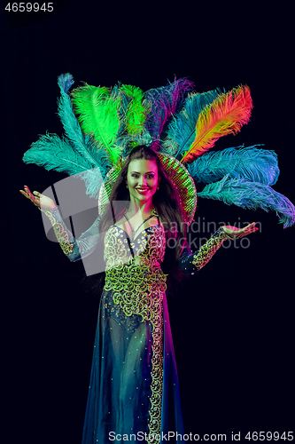 Image of Beautiful young woman in carnival peacock costume