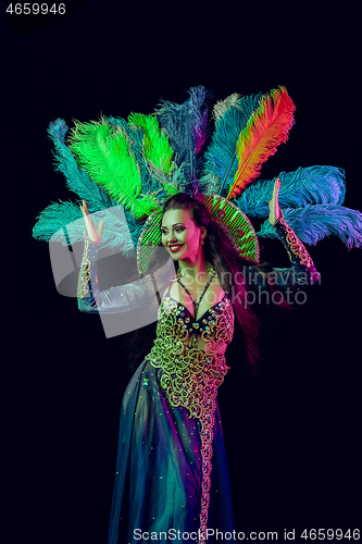 Image of Beautiful young woman in carnival peacock costume