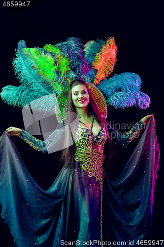 Image of Beautiful young woman in carnival peacock costume