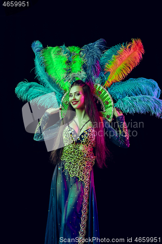 Image of Beautiful young woman in carnival peacock costume