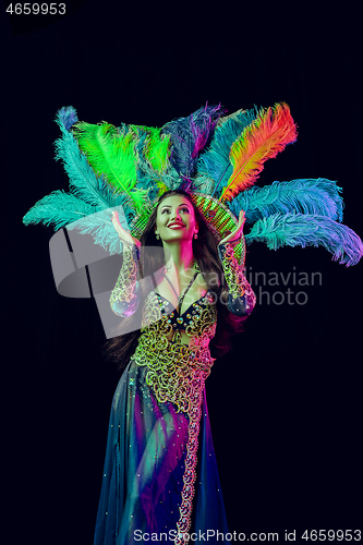 Image of Beautiful young woman in carnival peacock costume