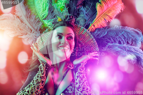 Image of Beautiful young woman in carnival peacock costume
