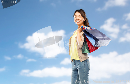 Image of happy asian woman with shopping bags