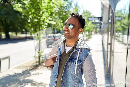 Image of indian man with backpack walking along city street