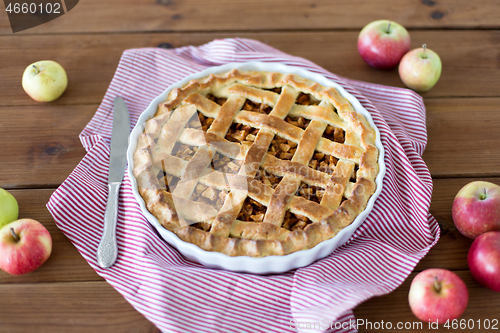 Image of close up of apple pie in baking mold and knife