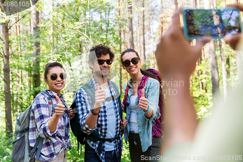 Image of friends with backpacks being photographed on hike