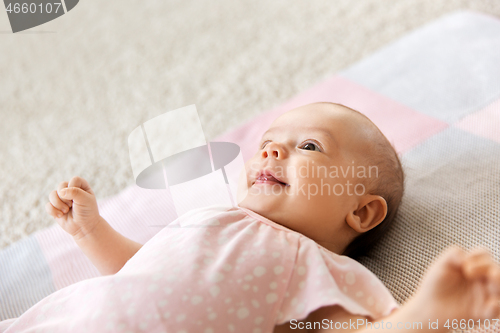 Image of sweet baby girl lying on knitted blanket