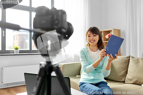 Image of asian female blogger making video review of book