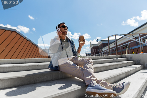 Image of man in headphones listening to music on roof top