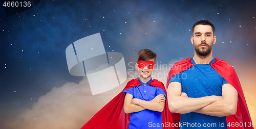 Image of father and son in superhero capes over night sky