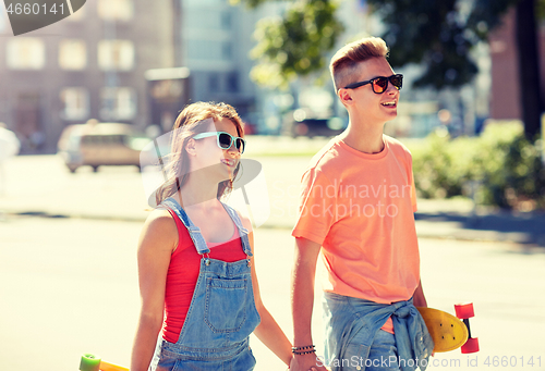 Image of teenage couple with skateboards on city street