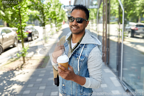 Image of indian man with bag and takeaway coffee in city