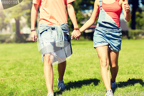 Image of happy teenage couple walking at summer park