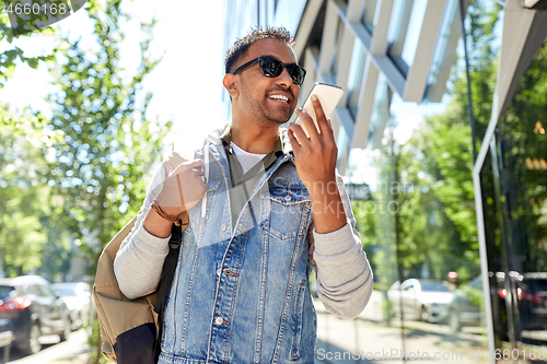 Image of man recorving voice message on smartphone in city