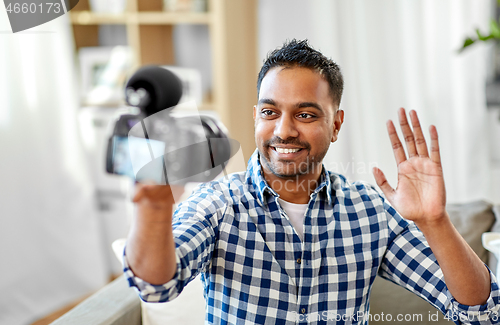 Image of male video blogger with camera blogging at home