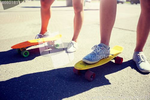 Image of teenage couple riding skateboards on city street