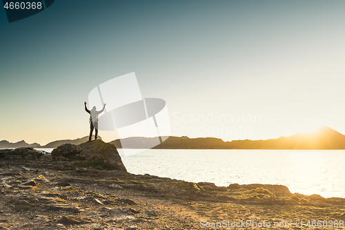 Image of Man exploring the coast line at sunset