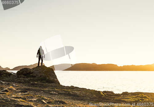 Image of Man exploring the coast line at sunset