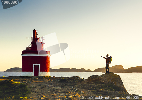 Image of Man exploring the coast line at sunset