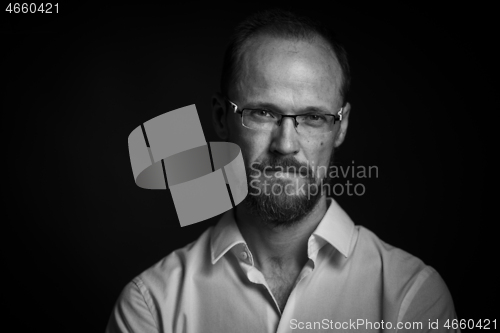 Image of Black and white portrait of man in glasses looking concentrated in camera