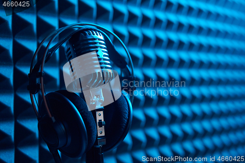 Image of Studio condenser microphone with professional headphones acoustic panel