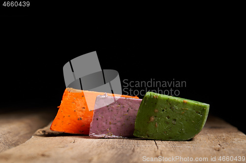 Image of Three different gourmet cheeses on rough woode planks