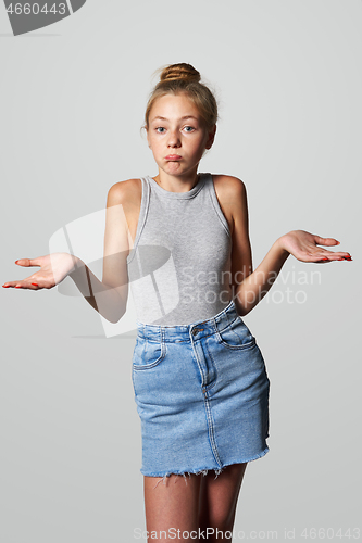 Image of Teen girl looking at camera shrugging her shoulders