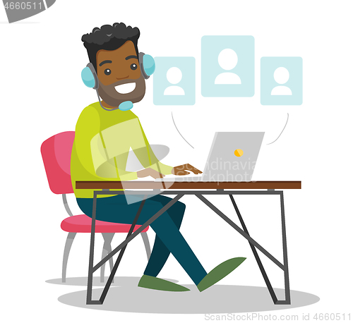 Image of A black man in headset working at the office desk.