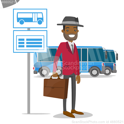 Image of A man waiting on a bus stop with timetable.