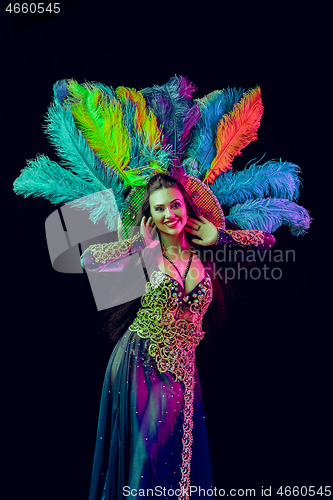 Image of Beautiful young woman in carnival peacock costume