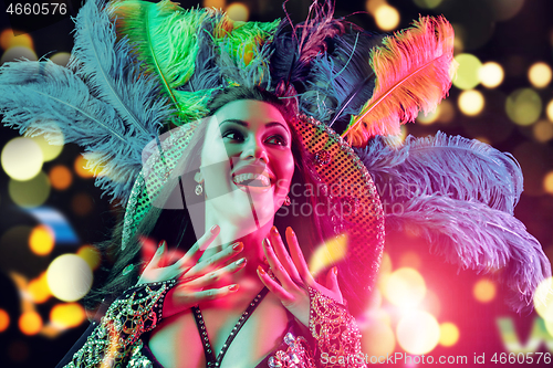 Image of Beautiful young woman in carnival peacock costume