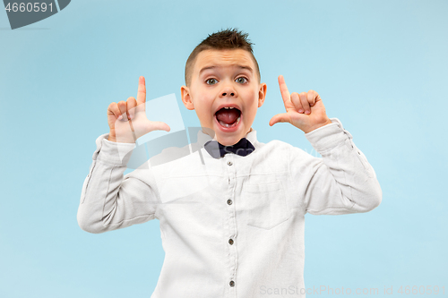 Image of Isolated on blue young casual boy shouting at studio